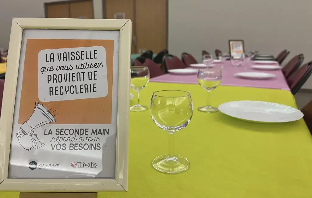 Une table dressée avec de la vaisselle Arcopal, des verres ballons et une nappe verte