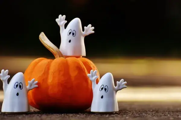 Des figurines de petits fantômes blancs jouent autour d'une citrouille