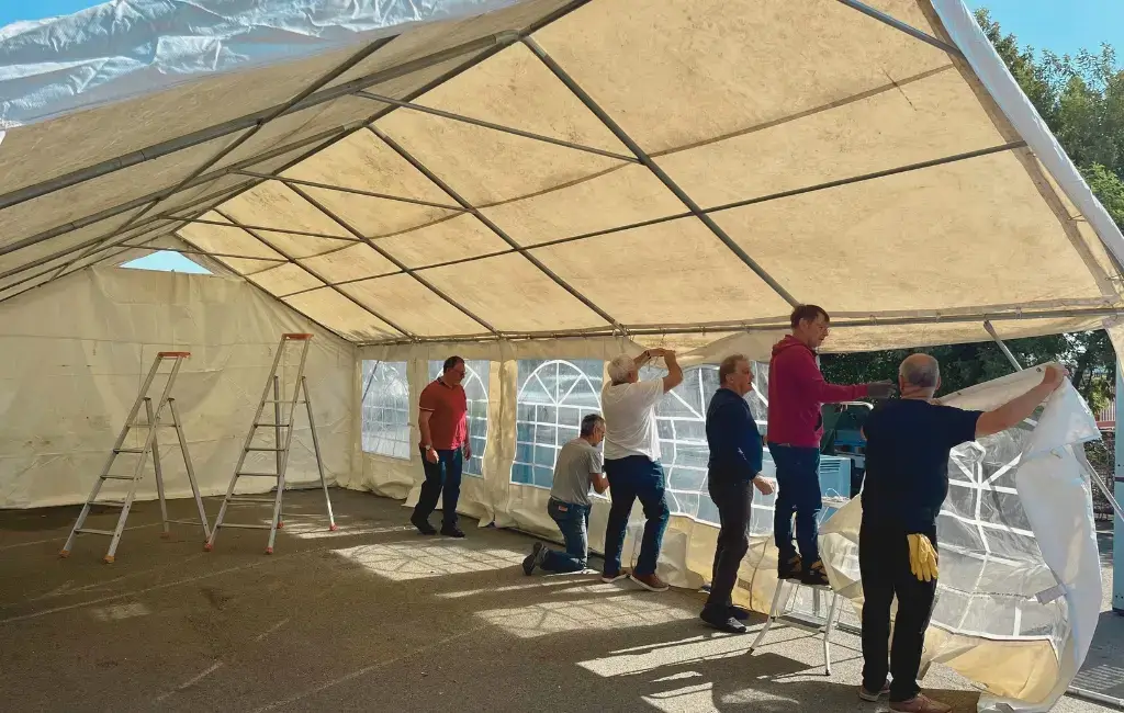 Six hommes installent un barnum