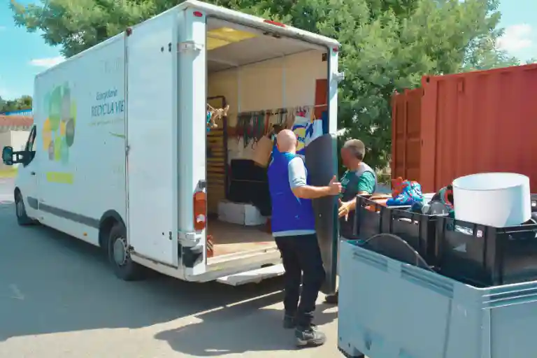 Deux hommes déposant une grande table dans un camion
