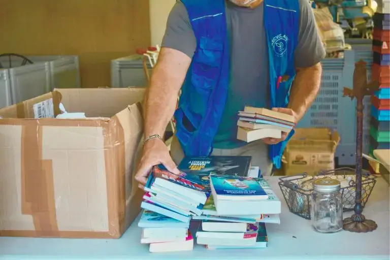Un homme qui trie des livres sortis d'un carton